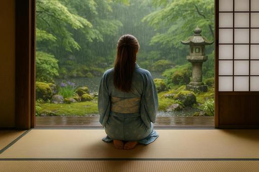 畳の部屋で雨の庭を眺める女性 畳の部屋で雨の庭を眺める女性の写真