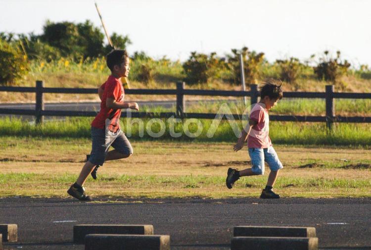 ＜素材＞夏の夕暮れの公園で元気に遊ぶ兄弟 子供,走る,歩くの写真素材