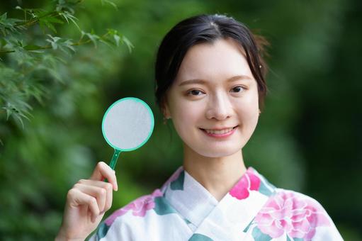 浴衣姿の女性がホイをもって微笑む 女性,浴衣,ポイの写真素材