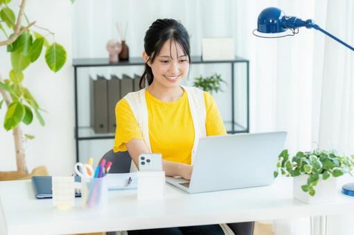 ノートパソコンを使う若い女性 笑顔,若い女性,ビジネスウーマンの写真素材