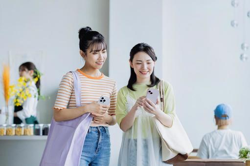 カフェでスマホを使う若い女性 カフェでスマホを使う若い女性 買い物,ショッピング,女性の写真素材