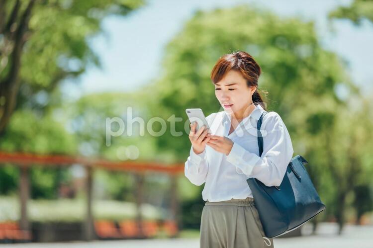 スマホを見てショックを受ける女性 ショック,悲しい,リストラの写真素材