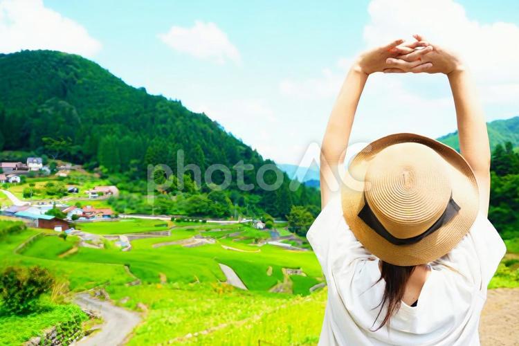 井仁の棚田で深呼吸する女性の後ろ姿 棚田,女性,後ろ姿の写真素材