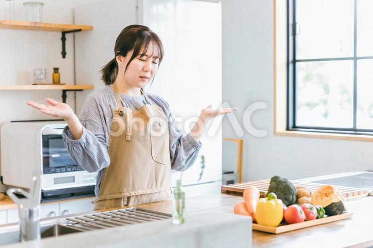 料理が苦手なエプロン姿の女性（お手上げ） キッチン,料理,苦手の写真素材