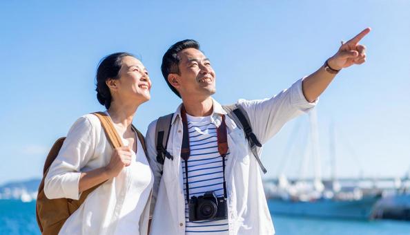 空を見上げている笑顔のミドル夫婦の写真