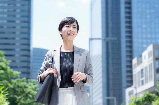 オフィス街で働く若いビジネスウーマン オフィス街で働く若いビジネスウーマンの写真