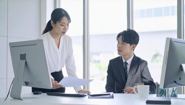 上司に報告する女性社員 上司に報告する女性社員の写真