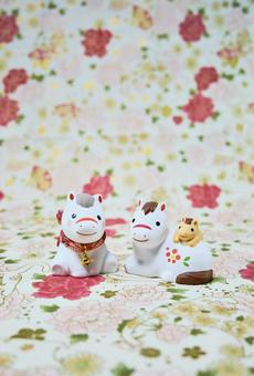 可愛い馬の置物と和柄の背景の年賀状素材の写真