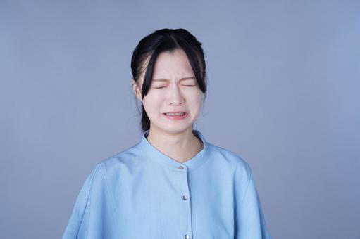 目をつむる青い服の女性の写真