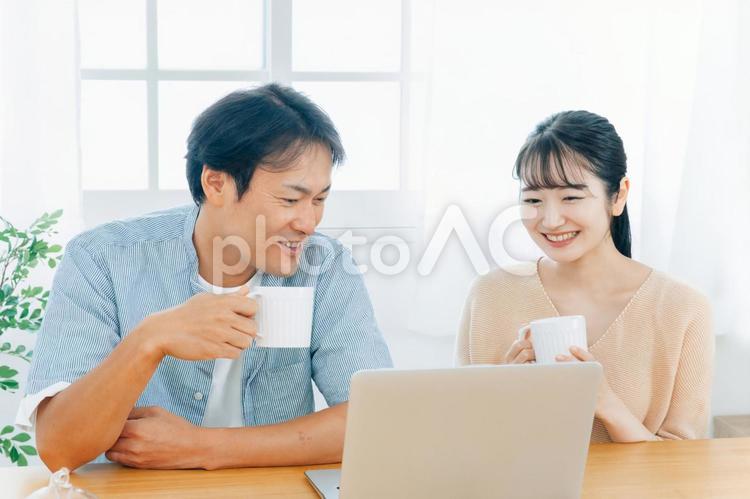 ノートパソコンを見る夫婦（笑顔） パソコン,光テレビ,動画の写真素材