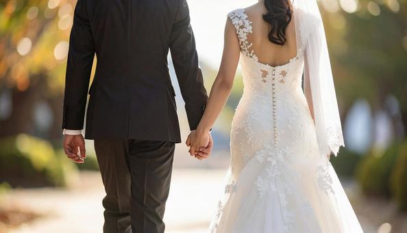 結婚式で手をつないで歩く新郎新婦の写真