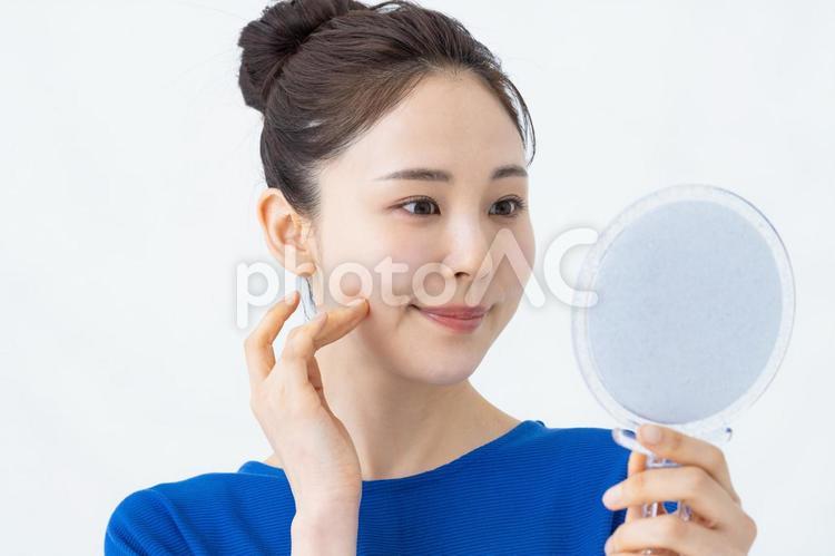 若い女性のビューティ スキンケア,鏡,肌の写真素材