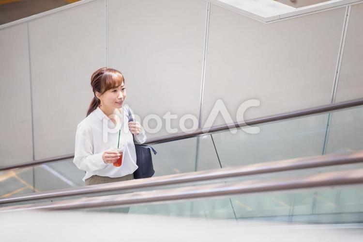 エスカレーターに乗る女性 エスカレーター,駅,通勤の写真素材