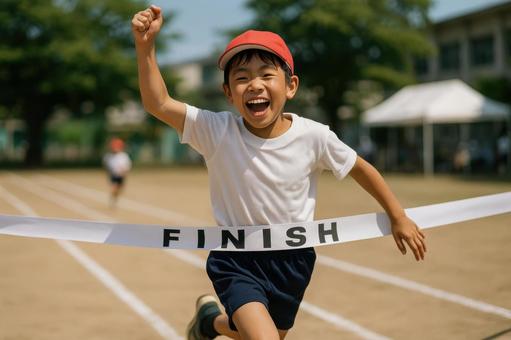 ゴールテープを切る小学生ランナー ゴールテープを切る小学生ランナーの写真
