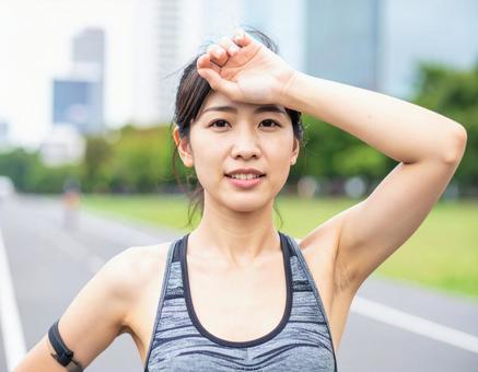汗を拭う女性 汗を拭う女性の写真
