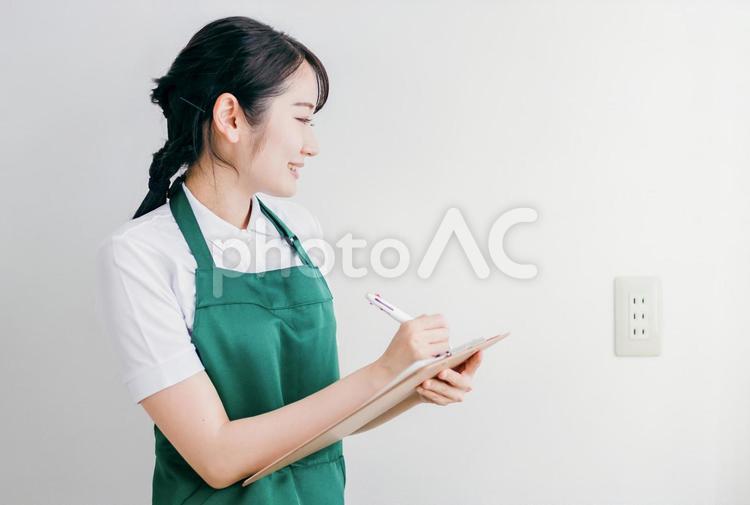 電源プラグの差し込み口を点検する女性 電源,電源プラグ,コンセントの写真素材