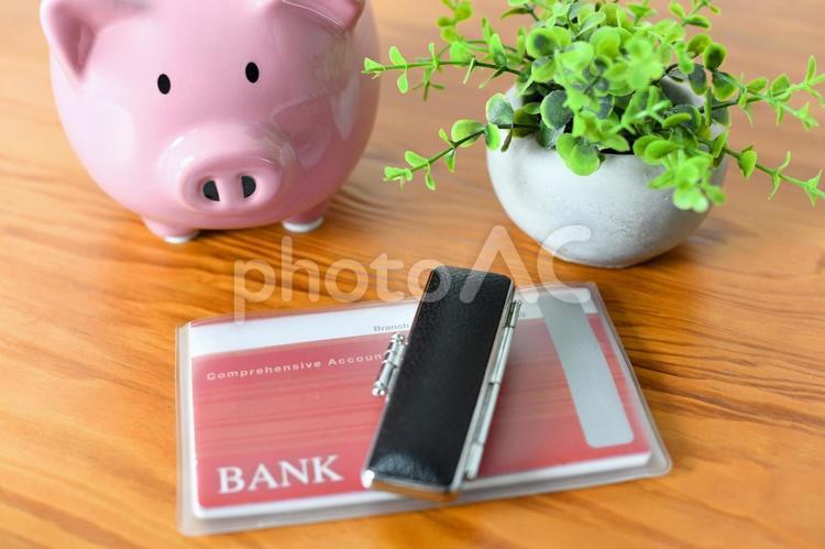 机に置かれた銀行通帳と印鑑と豚の貯金箱 貯金,貯蓄,預金の写真素材