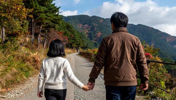 なごやかな雰囲気で森林を歩く家族の後ろ姿 なごやかな雰囲気で森林を歩く家族の後ろ姿の写真