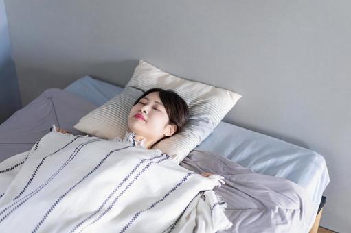ベッドで熟睡する若い女性 ベッドで熟睡する若い女性 寝顔,家,コピースペースの写真素材