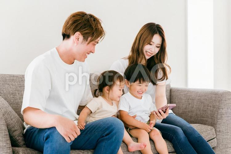 リビングでスマホを見る日本人家族（親子） スマホ,家族,アプリの写真素材