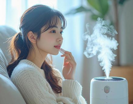 加湿器のそばでスキンケアをする女性の写真