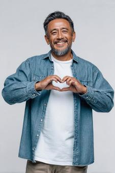 A man making a heart sign with a friendly expression, male, hispanic, a smile, JPG