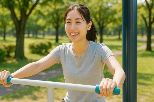 休日の公園の健康器具で運動する若い女性 休日の公園の健康器具で運動する若い女性の写真