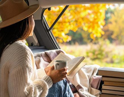 トランクで読書を楽しむ女性の写真