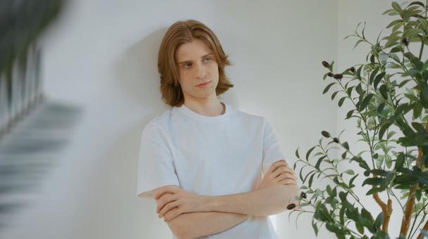 壁にもたれる腕組みをしている白いTシャツを着た男性 男性,外国人,欧米人の写真素材