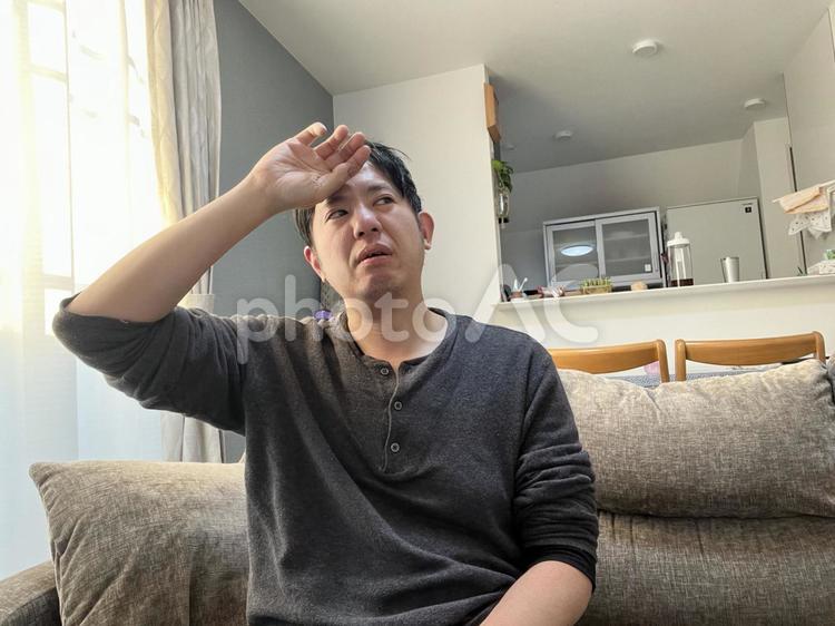 手を額に当てる男性　1 手,額,熱の写真素材