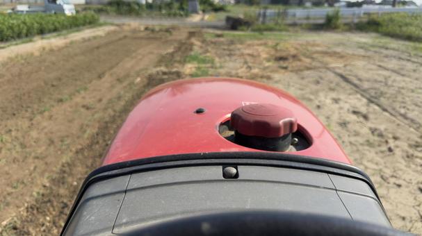 トラクター運転席から撮影、草の畑を耕す トラクター運転席から撮影、草の畑を耕すの写真