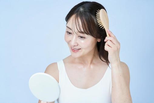 髪をブラッシングするミドル世代の女性 髪をブラッシングするミドル世代の女性 女性,頭皮,ヘアセットの写真素材