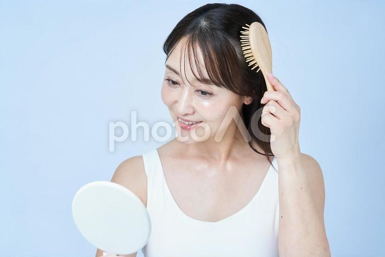 髪をブラッシングするミドル世代の女性 女性,頭皮,ヘアセットの写真素材