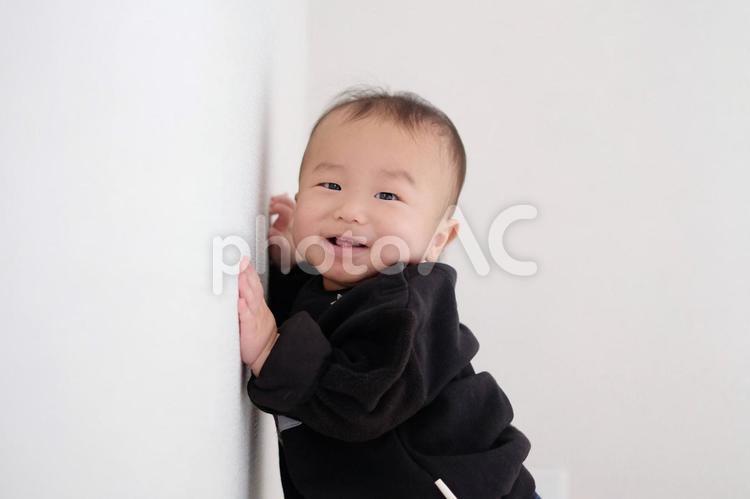 壁　つかまり立ち　赤ちゃん 赤ちゃん,笑顔,白背景の写真素材