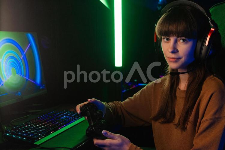 コントローラーを持ってカメラ目線の女性 ゲーマー,人物,女性の写真素材