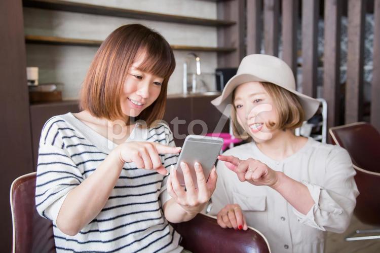 美容室でスマホを指さす女性 美容室,スマホ,ヘアカタログの写真素材