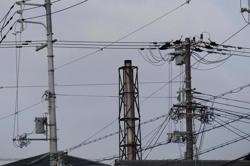 煙突と電柱と電線と屋根と空の見える町 煙突と電柱と電線と屋根と空の見える町の写真