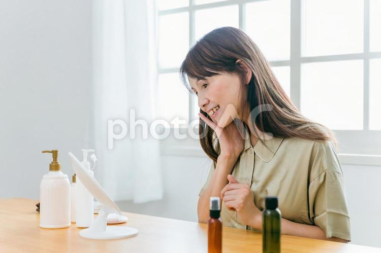 お肌を触るミドル世代の女性（笑顔） スキンケア,美容,保湿の写真素材