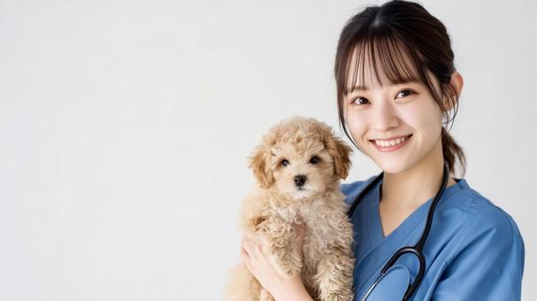 子犬を抱き優しく微笑む女性獣医師 子犬を抱き優しく微笑む女性獣医師の写真