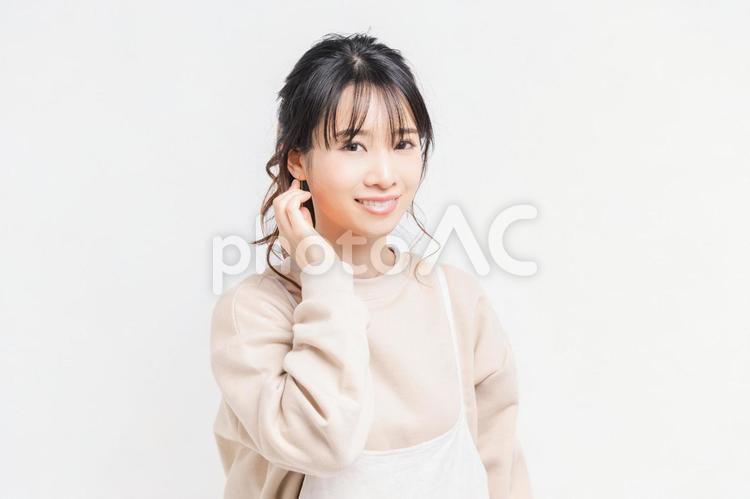 白い背景の前に立ってポーズをとる若い女性 女性,白背景,立つの写真素材