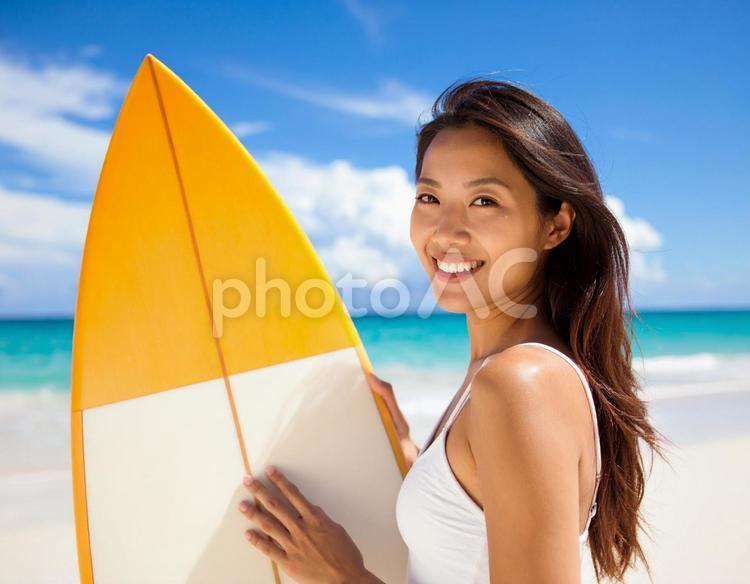 海でサーフボードを持った笑顔の女性 女性,サーフボード,1人の写真素材