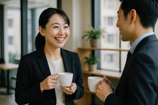同僚と談笑する女性社員 同僚と談笑する女性社員の写真