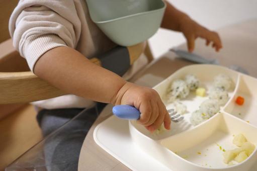 ご飯をフォークで練習しながら食べる子ども 子ども,幼児食,手づかみ食べの写真素材