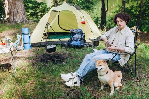 芝生に寝転び犬と並ぶ男性 男性,外国人,犬の写真素材