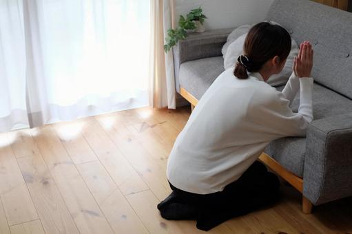 ソファーで祈る40代女性 女性,手,両手を組むの写真素材