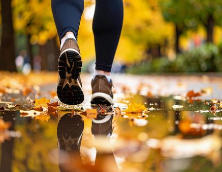 落ち葉の上を走るランナーの足元 落ち葉の上を走るランナーの足元の写真