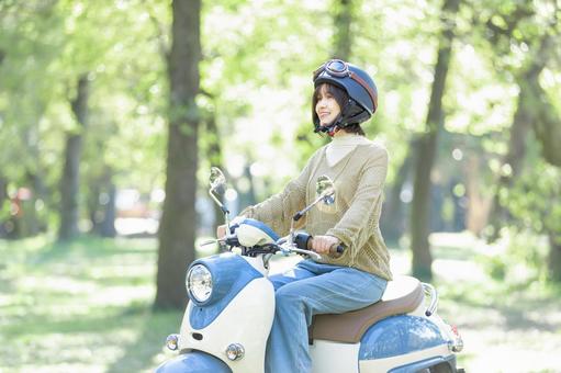 バイクに乗る若い女性 バイクに乗る若い女性 バイク,女性,スクーターの写真素材