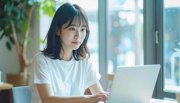 カフェでノートパソコンを使う日本人女性 カフェでノートパソコンを使う日本人女性の写真