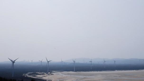 海沿いに立ち並ぶ風力発電の風車群 海沿いに立ち並ぶ風力発電の風車群の写真