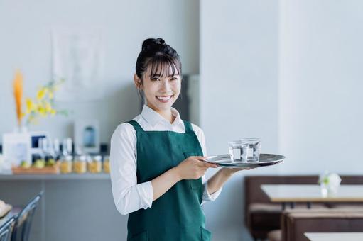 カフェで働く若い女性 カフェで働く若い女性の写真